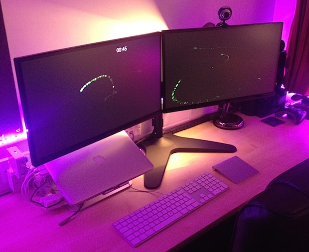MacBook Pro con pantalla Retina y monitores externos duales con iluminación ambiental personalizada